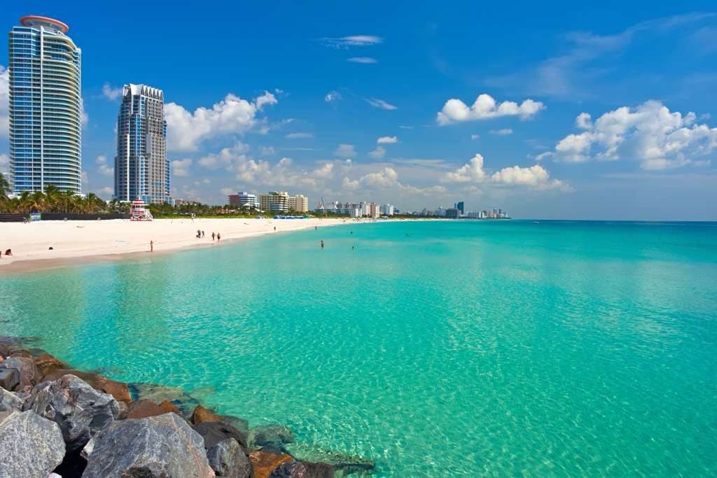 Turquoise water along a South Florida beach with the shoreline skyline beyond